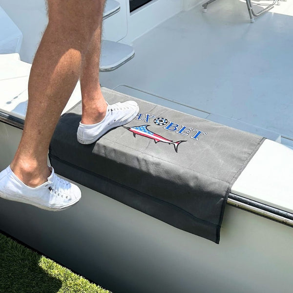 Person stepping onto a custom BoatMat Gunnel Boarding Mat with a Max Bet logo on a Sportfish Boat.