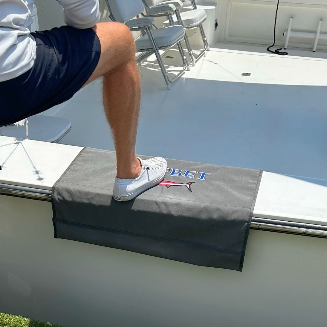 Person stepping onto a custom BoatMat Gunnel Boarding Mat with a Max Bet logo on a Sportfish Boat.