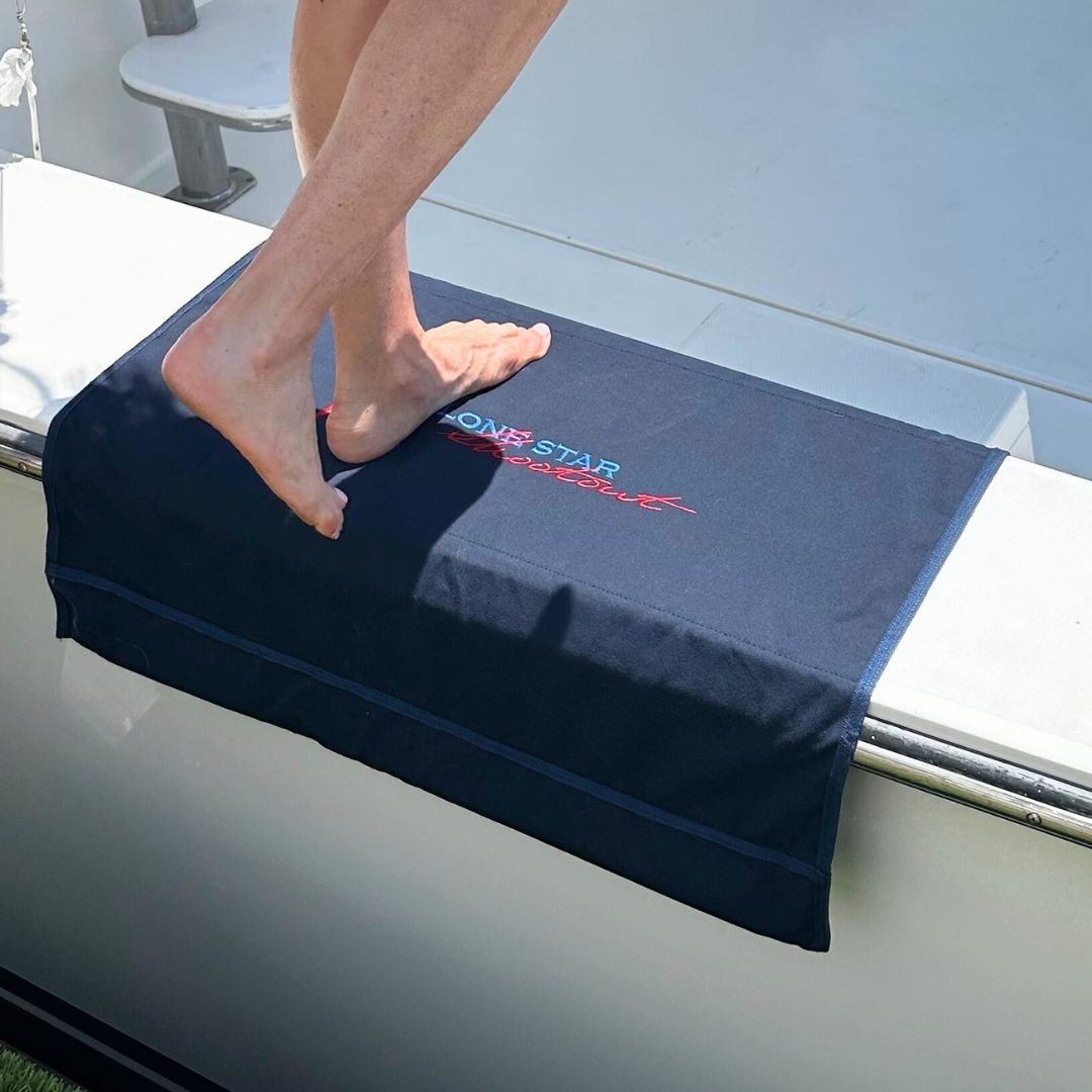 Person stepping onto a custom BoatMat Gunnel Boarding Mat with the Lone Star Shootout Sportfish Tournament logo on a Boat.