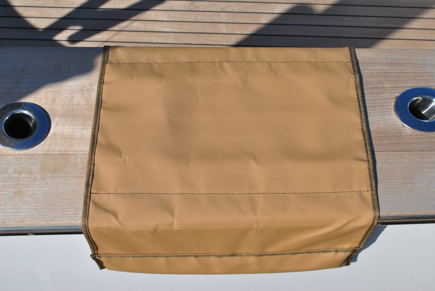 Tan Sunbrella boarding mat installed on a boat gunwale